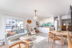 Ein modernes Wohnzimmer mit Sofa, Couchtisch und Esstisch.