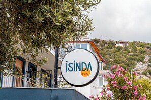 Ein Schild mit den Aufschriften 'ISINDA' und 'KAS', das ein Hotel oder eine Unterkunft kennzeichnet.
