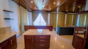 Una cocina con encimera de mármol, armarios de madera y un ventilador de techo.