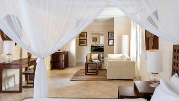 Una habitación de hotel con una cama, un sofá, una silla, una mesita y una lámpara.