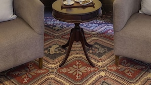 A bed with a canopy, two armchairs, a small round table with cups and pastries, and a patterned rug. - Billionaire Resort And Retreat (Malindi)