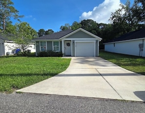 A single-story house with a front garage, a well-maintained lawn, and a clear sky. - Rest and Relaxation! Home away from home! Pet friendly! Convenient location! (St. Augustine)
