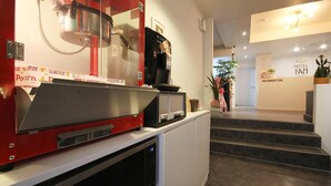 A hotel reception area with a coffee machine, a microwave, and a staircase leading to the information desk. - Hotel Yam Andong (Andong)