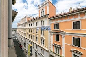Ein mehrgeschossiges Gebäude mit einer Reihe von Fenstern, Balkonen und Blick auf die Straße.