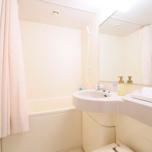 A bathroom with a bathtub, a sink, and a mirror. - Juraku Stay Niigata (Niigata)