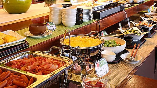 A buffet with various dishes, a potted plant, and a sign indicating a vegetarian option. - Juraku Stay Niigata (Niigata)
