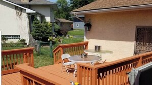 A wooden deck with a table and chairs, a hose, and a grill. - Spacious 5-bedroom house for corporate tenants (Columbus)