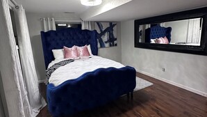 A bedroom with a large bed, a ceiling light, a window with a view, and a mirror on the wall. - Spacious 5-bedroom house for corporate tenants (Columbus)