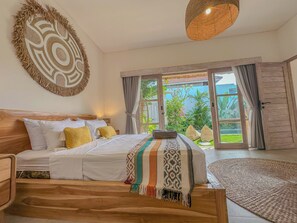 Ein Schlafzimmer mit einem Bett, einem Holzkopfteil, einem großen gewebten Wandbehang und Blick auf einen Garten durch eine Schiebetür.