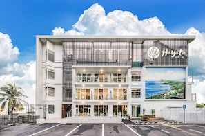A modern hotel with a prominent sign, multiple balconies, and a view of the sea. - Hayata Hotel No Children Under 12 Years Old (Hengchun)