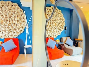 A modern room with a unique mushroom wall art, a white floor lamp, and vibrant orange and grey seating. - Hayata Hotel No Children Under 12 Years Old (Hengchun)