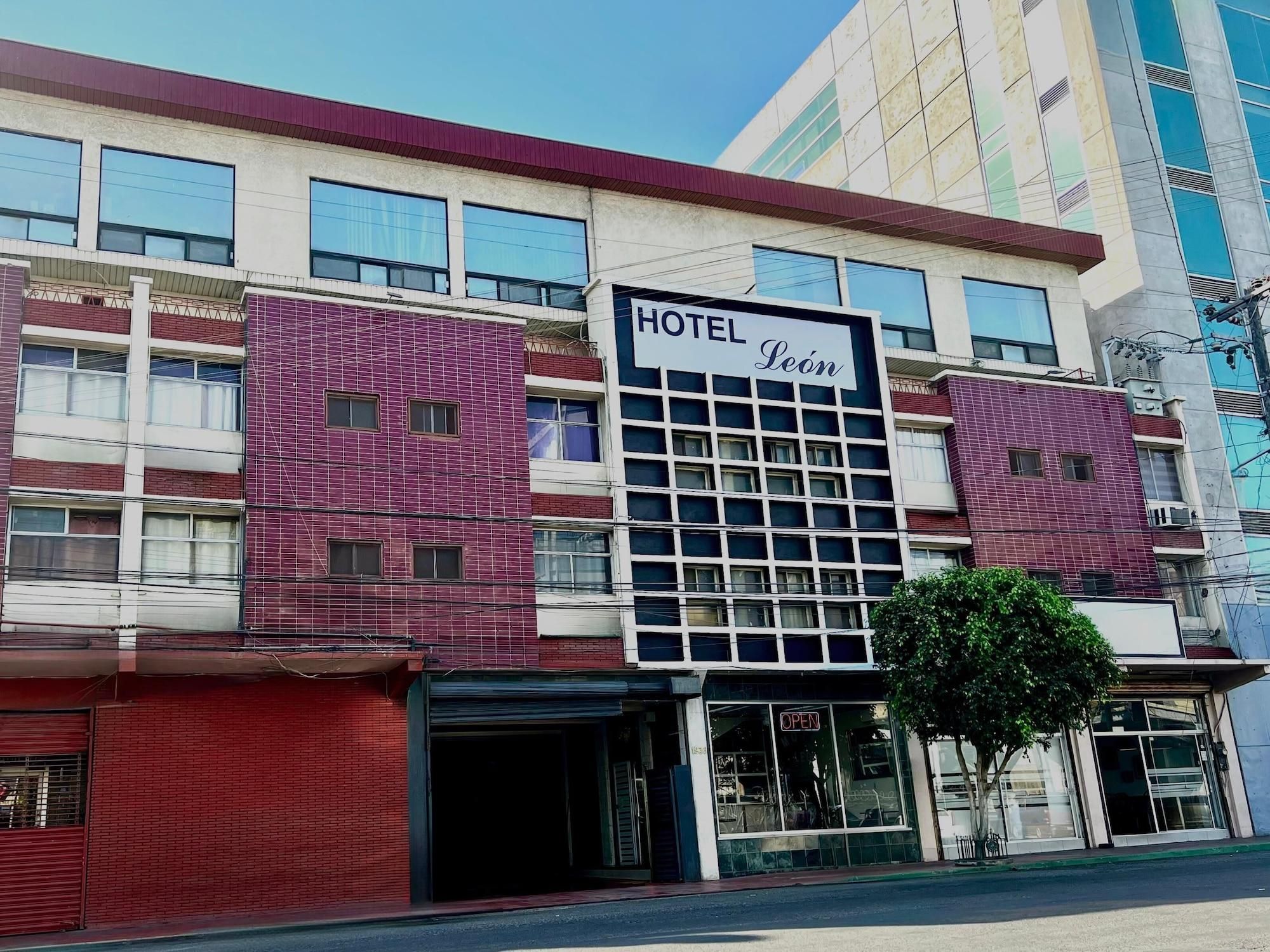 A hotel with a sign reading 'HOTEL Leôn,' featuring a modern facade with large windows and a prominent entrance.