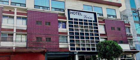 A hotel with a sign reading 'HOTEL Leôn,' featuring a modern facade with large windows and a prominent entrance.