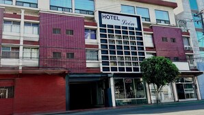 A hotel with a sign reading 'HOTEL Leôn,' featuring a modern facade with large windows and a prominent entrance. - Hotel Lea N (Tijuana)