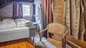 A room with a bed, a chair, wooden walls, a window, and curtains. - Amazing apartment in Tjørhom with sauna (Tjørhom)