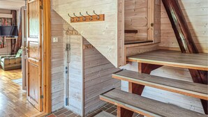 Een houten trap met houten leuning en een kapstok aan de muur.