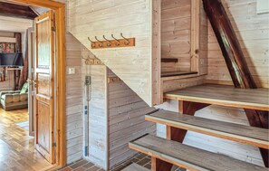 Un escalier en bois avec une rampe en bois et un porte-manteau fixé au mur.