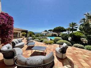 A patio with outdoor furniture, a swimming pool, and a view of the sea. - MAGNIFICENT VILLA WITH POOL AND SEA VIEW (STE MAXIME)