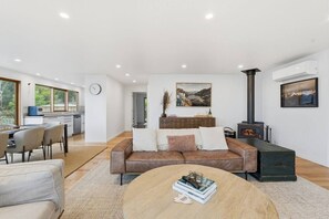 Een moderne woonkamer met een bank, salontafel en open haard.