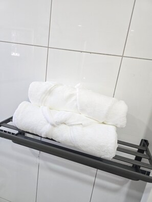 A rack with folded white towels. - THE NADI SUITE (Nadi)