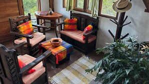 A cozy room with wooden furniture, a round table, and a view of greenery outside. - Island in the Sky--Shisa House
Small custom home built with love in Cahuasqui (Cahuasqui)
