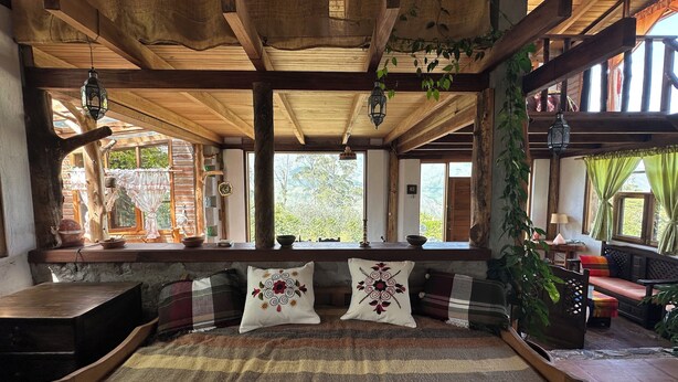 A rustic wooden room with a bed, windows, and hanging plants. - Island in the Sky--Shisa House
Small custom home built with love in Cahuasqui (Cahuasqui)