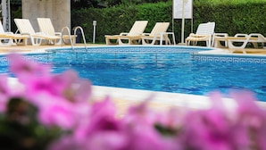 A swimming pool with lounge chairs and a signboard. - Hotel Karlovo Sunny Beach (Nessebar)