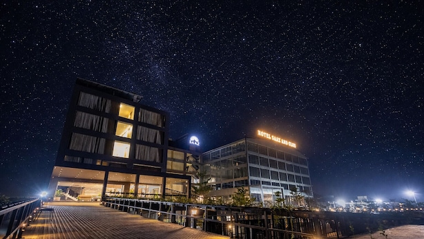 A modern hotel with a starry night sky, a well-lit entrance, and a clear view of the hotel's name. - Saaz Hotel Indore (Indore)