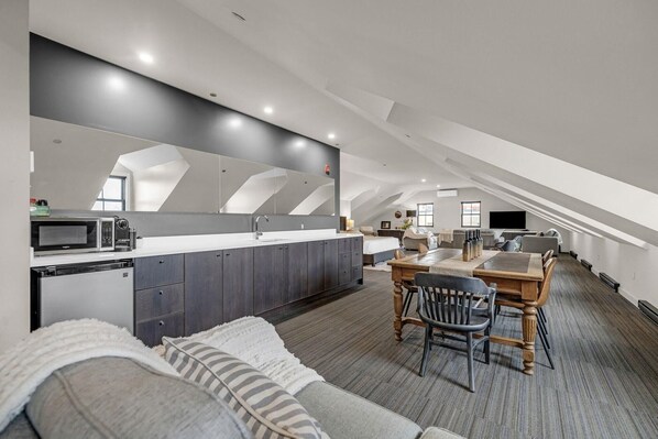 A modern loft-style apartment with a kitchen, dining area, and living space.