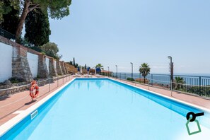 A swimming pool with a stone wall on one side and a view of the sea on the other. - Hotiday Bordighera (Bordighera)