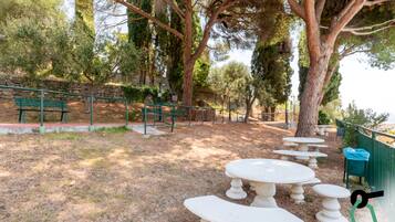 Un parc doté d’un espace extérieur aménagé avec des sièges, des murs en pierre et des arbres.