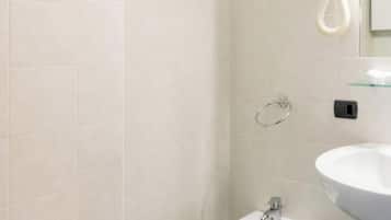 Un baño con inodoro, bidé y lavamanos.