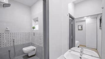 Un baño moderno con inodoro, lavabo y ducha.