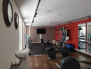 A gym with exercise equipment, a television, and a mirror. - Ermita Cartagena, A Tribute Portfolio Hotel (Cartagena)