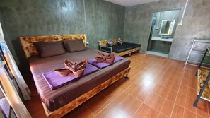 A room with a bed, a small table, and a mirror.