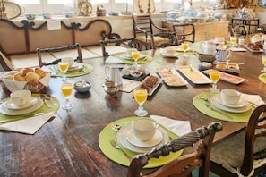 A dining table set with breakfast items, including pastries, bread, and beverages. - Quinta Da Alcaidaria-mór (Ourem)