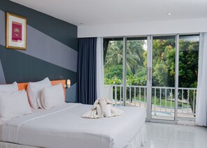 Una habitación de hotel con una cama grande, vistas al exterior y un balcón.