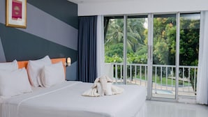 Una habitación de hotel con una cama grande, vistas al exterior y un balcón.