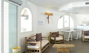 A room with wooden furniture, including sofas and a table, and large windows.