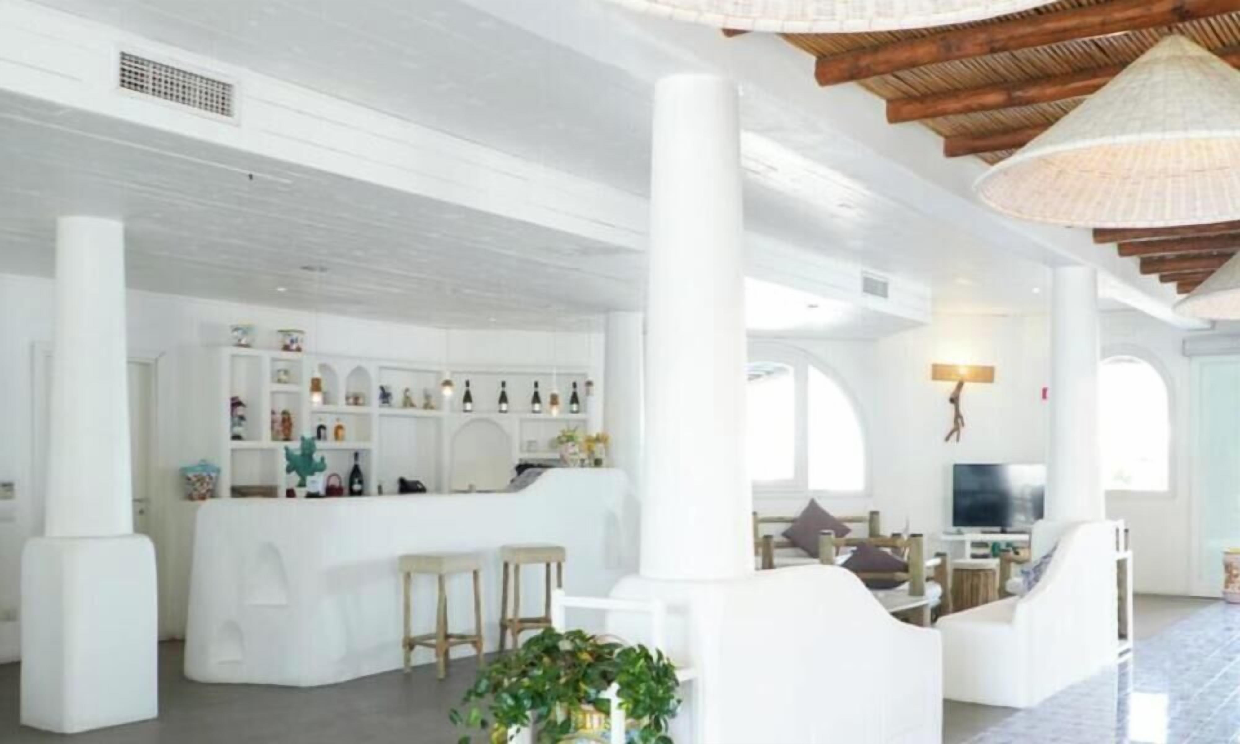 A spacious interior with a central bar area, seating arrangements, and a television.