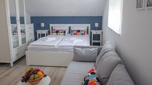 Un dormitorio con cama, mesita de noche, armario, sofá y frutero.