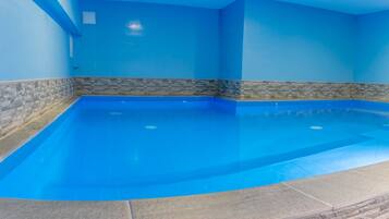 An indoor swimming pool with blue walls and stone accents.