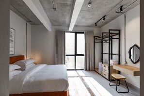 A modern bedroom with a bed, a desk, a wardrobe, and a large window. - C Living 3 (Madinat Zayed)