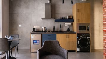 Une cuisine compacte équipée d’un lave-vaisselle, d’un four à micro-ondes et d’une machine à laver.