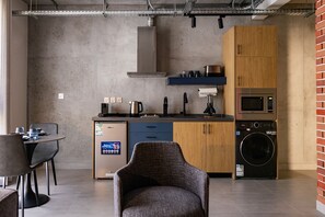 A compact kitchen with a dishwasher, microwave, and a washing machine. - C Living 3 (Madinat Zayed)