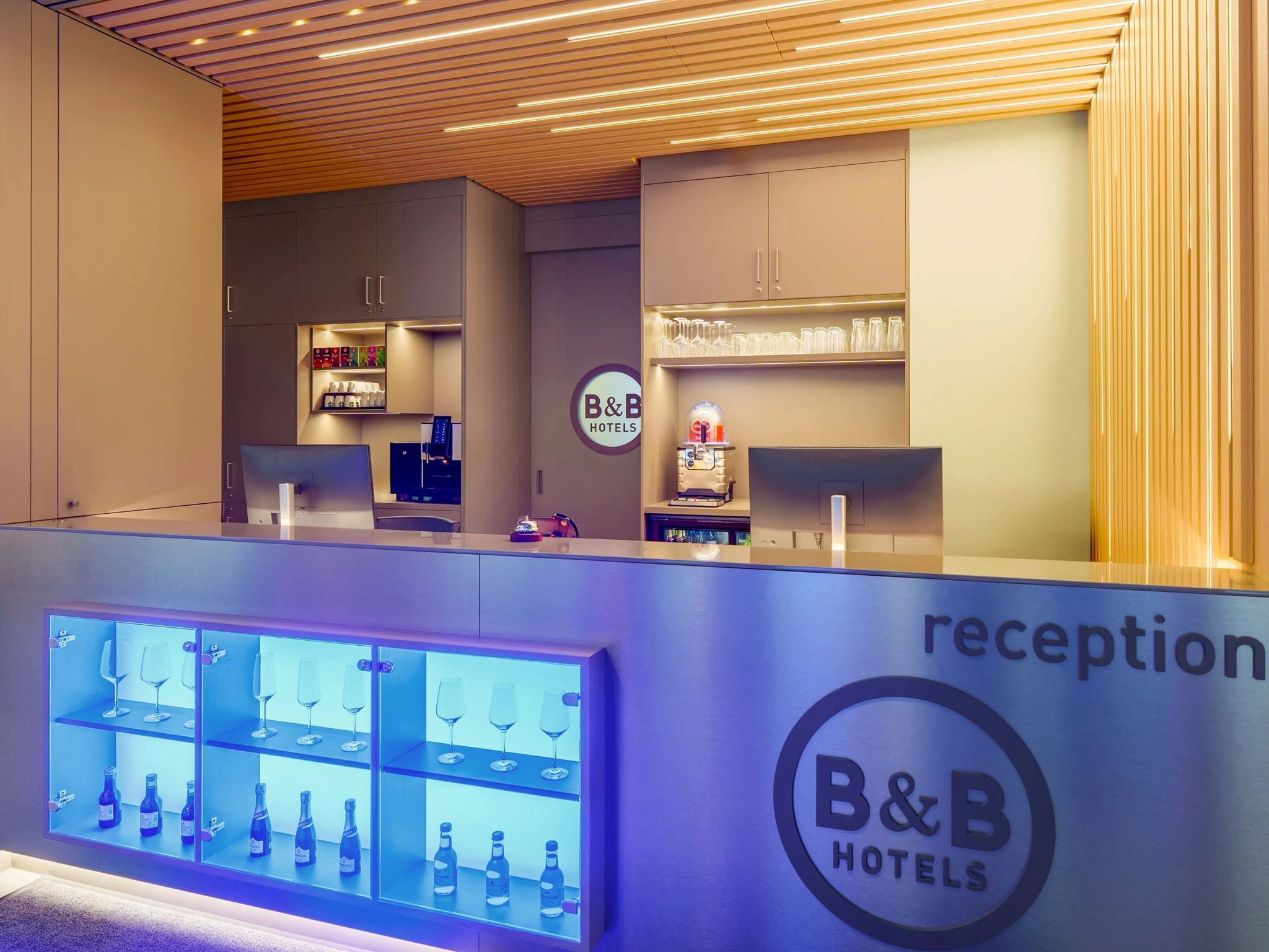 A reception area with a counter, a robot, and a display of wine glasses and bottles.