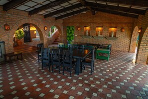 A brick-walled dining area with a tiled floor, benches, and a staircase.