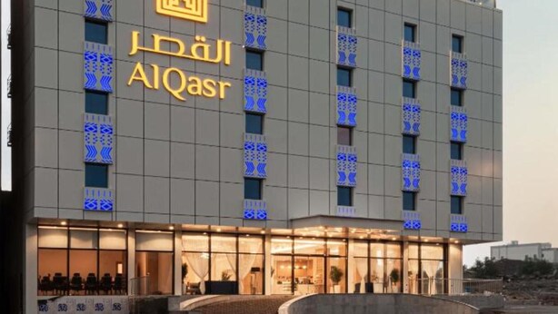 A modern hotel building with a prominent crown logo and the name 'AIQasr' displayed on the facade. - Al Qasr Al Rabwah (Abha)