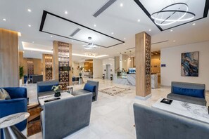 A spacious lobby with modern furniture, a reception desk, and a kitchen area in the background. - Al Qasr Al Rabwah (Abha)