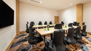 A conference room with a large table, black chairs, and a flat-screen TV. - Al Qasr Al Rabwah (Abha)